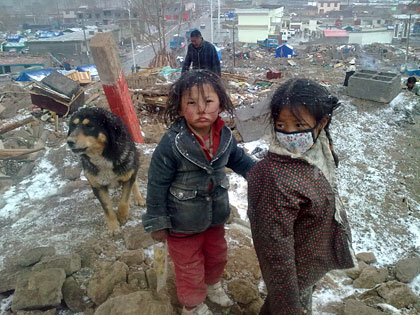 Children shiver in fresh snow falling over Yushu, seven days after the earthquake